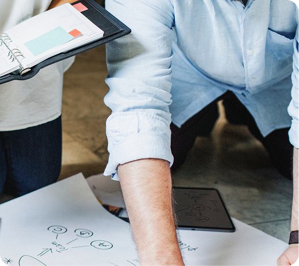 People working through notes and diagrams at a table