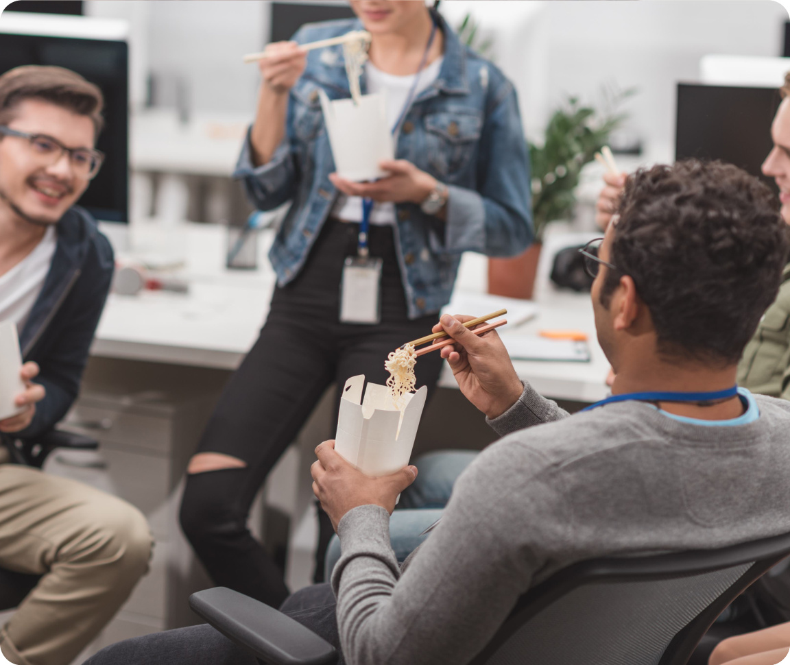 Colleagues sharing lunch and chatting in the office